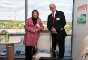 Pat and Jeff Gallahue pose with one of the comfy chairs that they helped purchase for area hospitals.