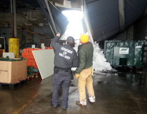 A representative from the Dept. of Public Safety and Building Commissioner Ed Walsh examine the collapsed roof at the DXL loading dock. (CFD photo)