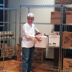 Ann Hartstein, Temple Beth Abraham's social action chair, stocks the shelves before the first food distribution.