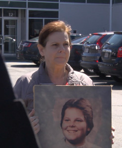 Jeanne Quinn holds a portrait of her son Shaun outside the parole board office.