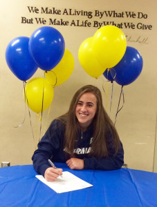 Hannah Link signs her letter of intent to run track at Merrimack College.