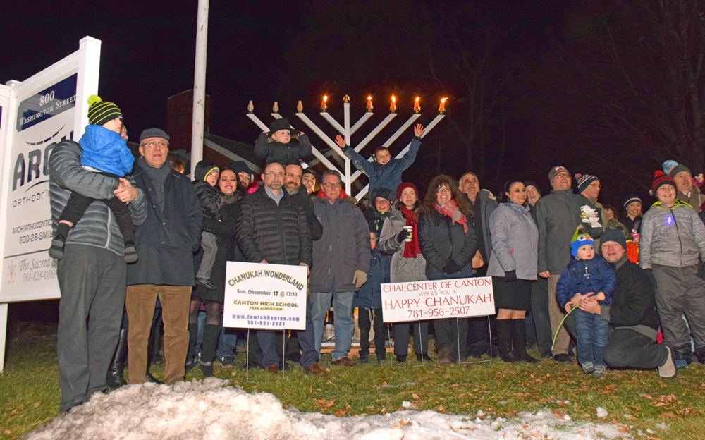 Local residents gather in front of ARCH Orthodontics for a menorah-lighting ceremony. (Moira Sweetland photo)